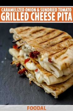 a close up of a quesadilla on a black surface with other food items