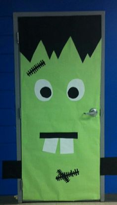 a green door with a monster face painted on it