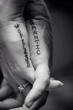 two people holding hands with tattoos on their fingers and the words ranjitto written on them