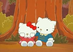 two hello kitty sitting next to each other in front of a tree