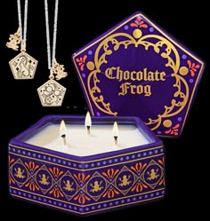 the chocolate frog candle is next to two necklaces and a box with charms on it