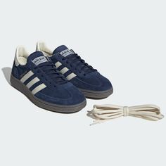 a pair of blue adidas sneakers next to a white shoelaced shoe string