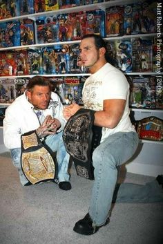 two men sitting on the floor with their wrestling gear