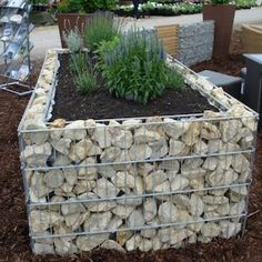 a planter made out of rocks sitting on the ground