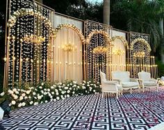 an outdoor wedding setup with white flowers and chandeliers on the wall, surrounded by greenery