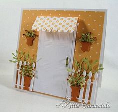 a card with potted plants and a white door on the front, which is decorated with polka dots