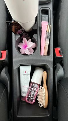 the interior of a car with cosmetics and other items in its holder on the back seat