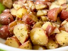 a white bowl filled with potatoes and meat