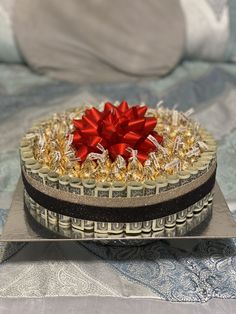 a cake with a red bow on top of it sitting on a silver platter