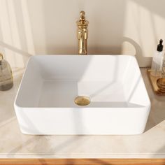 a white square sink sitting on top of a counter next to a faucet