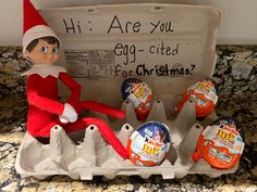 an elf is sitting on top of eggs in an egg carton