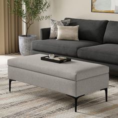 a living room with a gray couch and ottoman