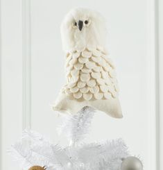 an owl ornament hanging from a white christmas tree