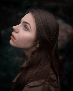 a woman with long hair looking up into the sky