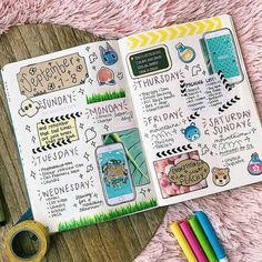 an open planner with stickers on it next to some markers and pencils,