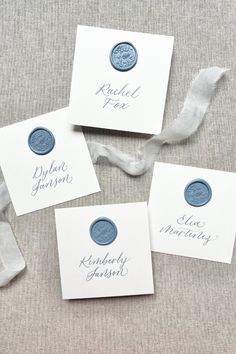 four blue wax seals on white cards with ribbons around them and the words rachel jones written in cursive ink