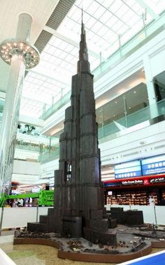 a model of a large building in a mall with people walking around the area and looking at it