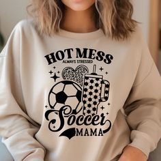 a woman wearing a sweatshirt that says hot mess soccer mama