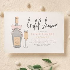 a bridal shower card with a bottle of champagne and two glasses on top of it