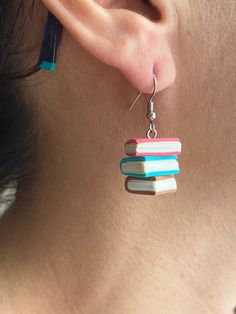 a close up of a person's ear with books dangling from it