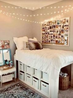 a white bed sitting in a bedroom next to a window with lights on the ceiling