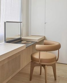 a chair sitting in front of a window next to a wooden desk and counter top