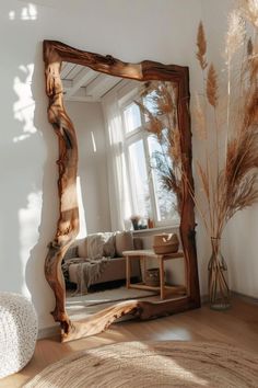 a large mirror sitting on top of a wooden floor next to a couch in a living room