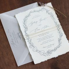 the wedding stationery is laid out on top of an envelope and tied with twine