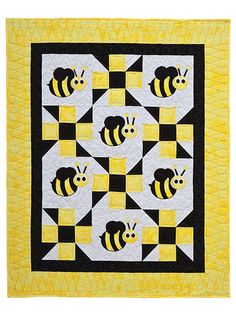 a yellow and black quilt with three bees on the front, one in the center