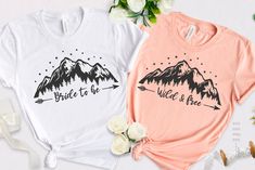 two t - shirts that say bride to be and the mountains are in black ink