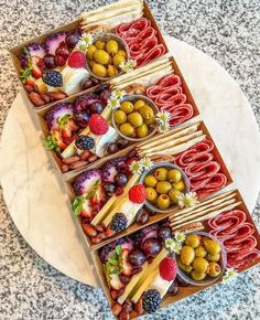 an assortment of food is displayed on a platter with utensils and olives