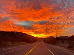 the sun is setting on an empty road