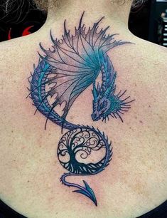 the back of a woman's neck with a blue dragon tattoo on her shoulder