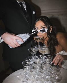 a bride and groom are pouring champagne into wine glasses