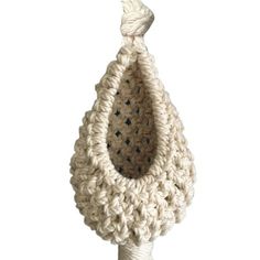 a white crocheted basket hanging from a hook