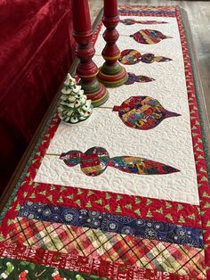 a quilted table runner with candles on it