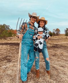 a man, woman and child are posing for a photo in the field with their farm equipment