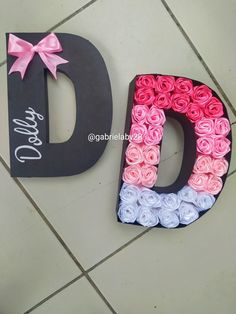 the letters are made out of paper roses and one has a pink bow on it