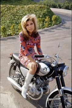 a woman sitting on top of a motorcycle