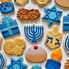 many decorated cookies are arranged on a white surface with hanukkah candles and menorahs