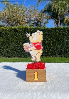 a winnie the pooh centerpiece sitting on top of a box in the snow