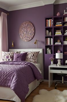 a bedroom decorated in purple and white with bookshelves on either side of the bed