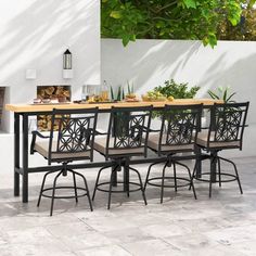 an outdoor dining table with six chairs and a potted plant on the back wall