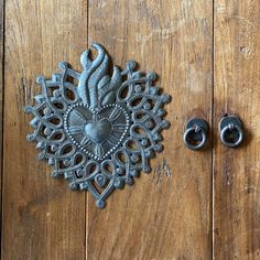 an ornate metal clock sitting on top of a wooden table next to two black handles