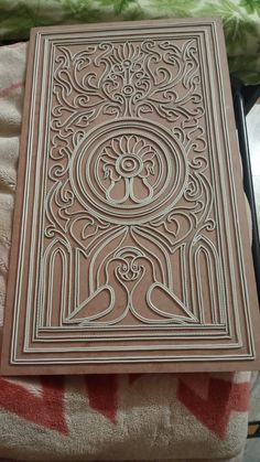 an intricately carved book sitting on top of a bed