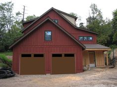 two garages are in front of a red barn