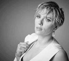 a black and white photo of a woman with short hair holding a towel over her shoulder