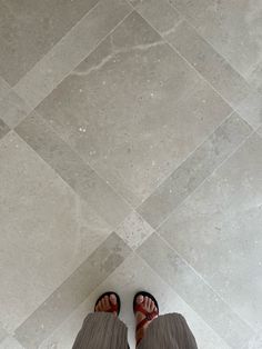 a person standing in front of a tile floor