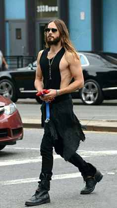 a man with long hair is walking down the street