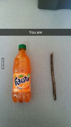 a bottle of orange soda sitting on top of a table next to a piece of wood